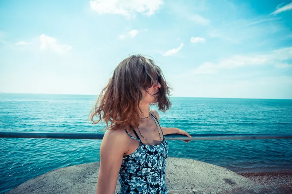 Jovem mulher num cais junto ao oceano — Fotografia de Stock