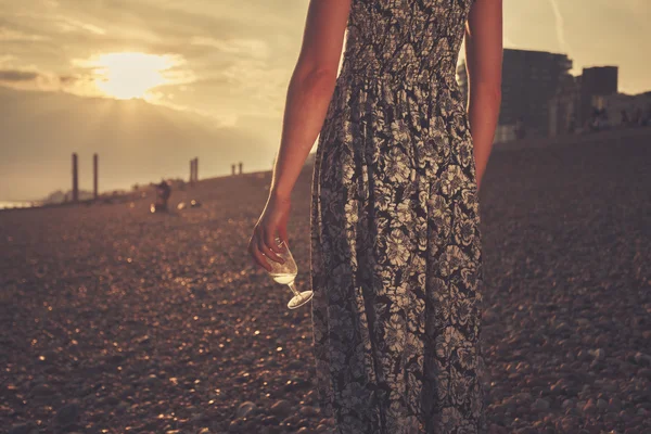 Jonge vrouw op het strand met glas wijn — Stockfoto