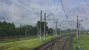 4k, demiryoluna giden bir trenin ıslak ön camından görüş.