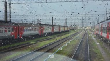 4k, demiryoluna giden bir trenin ıslak ön camından görüş.