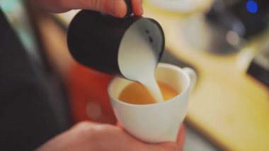 4k, kahve barmeni kapuçino, latte sanatı, yavaş çekim için espresso kahvesine süt koyuyor.