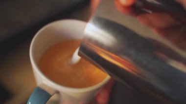 4k, kahve barmeni kapuçino, latte sanatı, yavaş çekim için espresso kahvesine süt koyuyor.