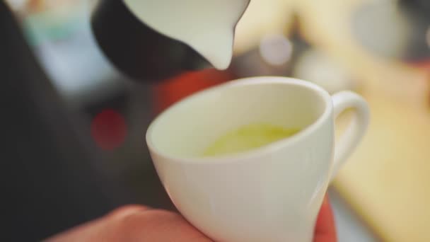 4k, Barista schenkt melk in thee en bereidt matcha latte, slow motion — Stockvideo