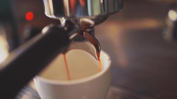 4k, espresso koffie giet uit de koffiemachine in een witte beker, slow motion — Stockvideo