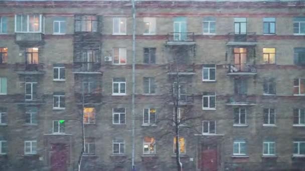 4k, vista de un edificio residencial de varios pisos durante las fuertes nevadas y el viento — Vídeos de Stock