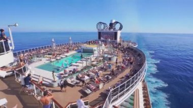 4k, üst güvertenin panoramik manzarası ve açık denizde insanlarla dolu bir yolcu gemisinin yüzme havuzu.