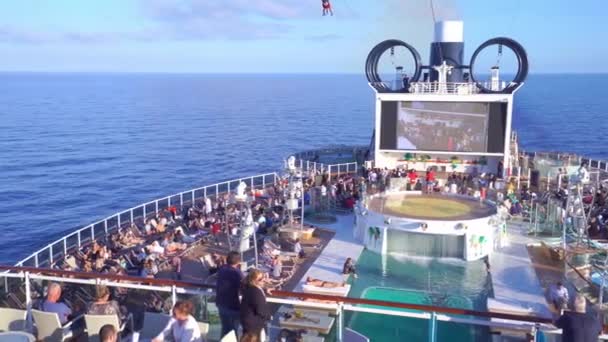 4k, panoramautsikt over øvre dekk og svømmebasseng på cruiseskip MSC Seaview med personer på åpent hav – stockvideo