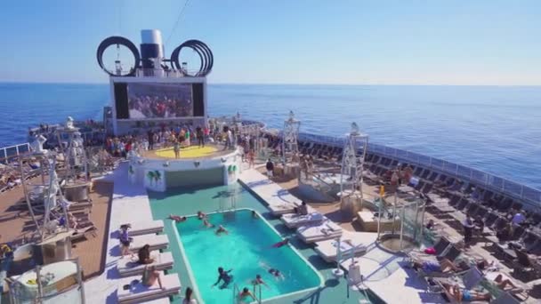 4k, panoramautsikt över övre däck och pool av ett kryssningsfartyg MSC Seaview med människor på öppet hav — Stockvideo