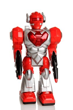 Parlak kırmızı renkli pillerle çalışan, ışık ve sesle çalışan, beyaz bir arka planda izole edilmiş mekanik bir oyuncak robot.