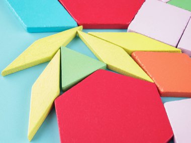 Ahşap yapıcı, farklı şekil ve yapılardan oluşan çok renkli bloklardan yapılmış, çocuklar için bir yapboz oyuncağı.