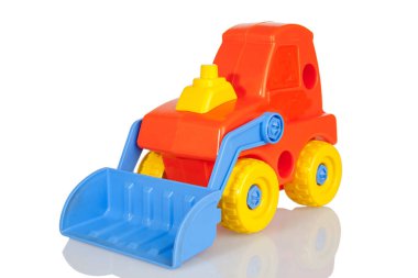 Hareket edebilir kovalı parlak turuncu plastik buldozer, oyuncak üreticisi, parçalara ayrılabilir, beyaz bir arka planda izole edilmiş.