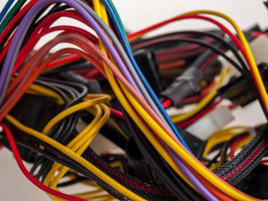 Elektrik kabloları yakın çekimde ve arka planda, elektrikli aletleri ve ekipmanları bağlamak için çok renkli kablolar