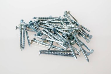 Metal çiviler, yakın plan, beyaz arka plan, inşaat için küçük çiviler, ev onarımı.