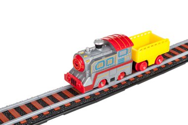 Oyuncak tren, lokomotif, pille çalışan buharlı lokomotif elektrikli motor, römork, araba, demiryolu rayları, beyaz arka planda izole edilmiş.