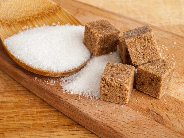 Açúcar Cana Cubos Açúcar Branco Comum Espalhado Uma Colher Madeira — Fotografia de Stock
