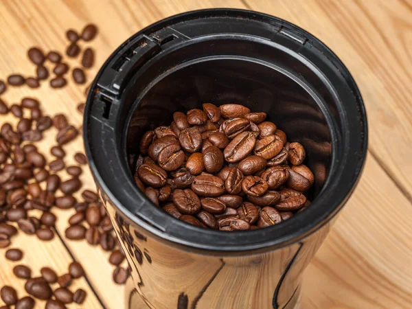 涂有烤咖啡豆的电动研磨机 用于制作咖啡 浓缩咖啡 卡布奇诺 图库图片