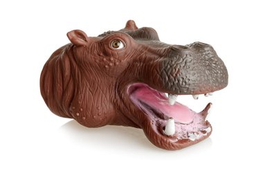 Ağzı açık bir eldiven, elinde su aygırı şeklinde bir oyuncak, beyaz bir arka planda izole edilmiş.