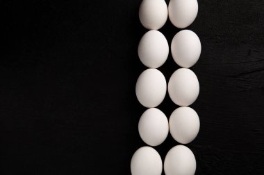 Siyah arka planda beyaz tavuk yumurtaları. Çiftlik ürünleri. Doğal yumurtalar. Tavuk yumurtaları masada.
