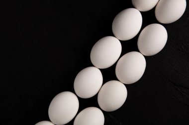 Siyah arka planda beyaz tavuk yumurtaları. Çiftlik ürünleri. Doğal yumurtalar. Tavuk yumurtaları masada.