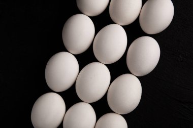 Siyah arka planda beyaz tavuk yumurtaları. Çiftlik ürünleri. Doğal yumurtalar. Tavuk yumurtaları masada.