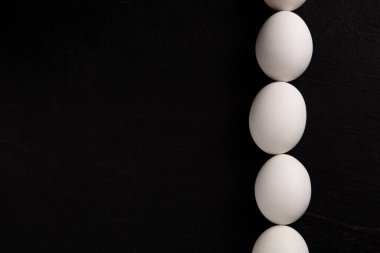 Siyah arka planda beyaz tavuk yumurtaları. Çiftlik ürünleri. Doğal yumurtalar. Tavuk yumurtaları masada.