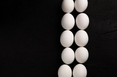 Siyah arka planda beyaz tavuk yumurtaları. Çiftlik ürünleri. Doğal yumurtalar. Tavuk yumurtaları masada.