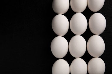 Siyah arka planda beyaz tavuk yumurtaları. Çiftlik ürünleri. Doğal yumurtalar. Tavuk yumurtaları masada.