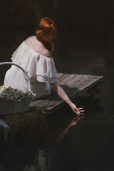 Rıhtımdaki kız elinde sepetle suyun üstünde — Stok fotoğraf