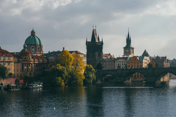 view of the Charles Bridge and the architecture of the old town of Prague, Czech Republic. Boats on the river. Beautiful old town in autumn