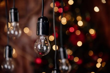 Noel ağacının ve çelenklerin arka planında ampuller 