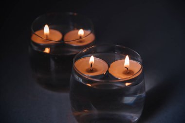 Mumları şamdanların içinde, suyun üzerinde yaktım.