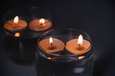 Mumları şamdanların içinde, suyun üzerinde yaktım.