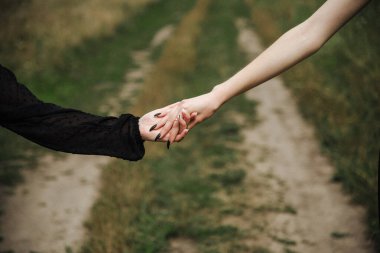 İki kız el ele tutuşuyor.