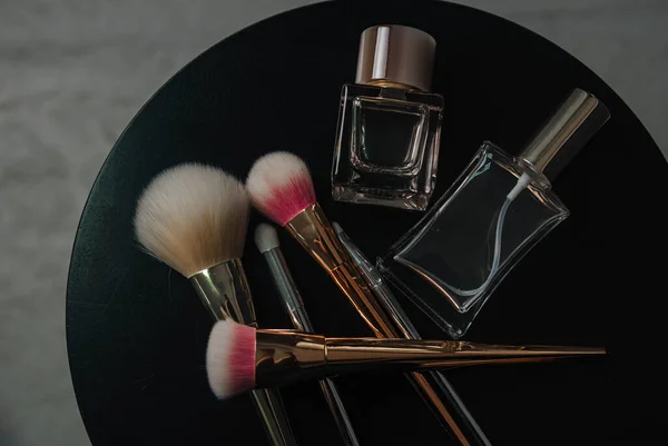 perfume and makeup kit on a dark background
