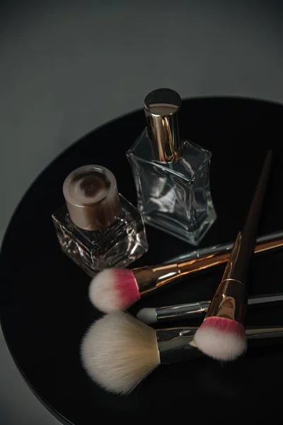 perfume and makeup kit on a dark background