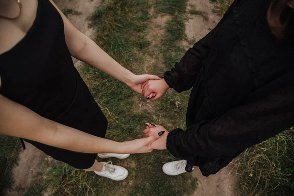 two girls are holding hands