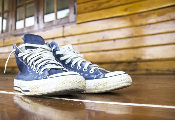 Blue sneakers on the wooden floor — Stock Photo, Image