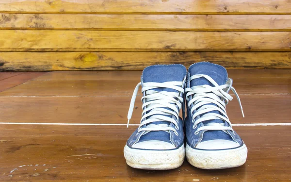 Blue sneakers on the wooden floor — Stock Photo, Image