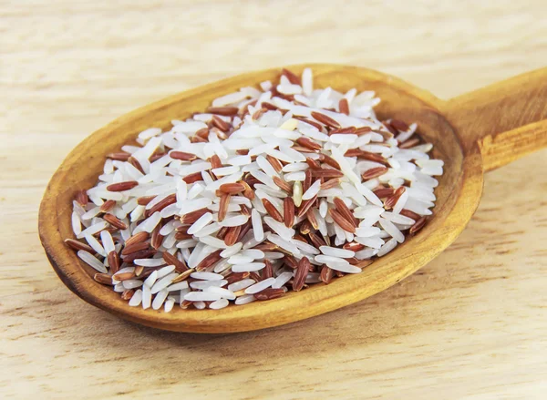 Jasmine rice and Brown Rice on wooden spoon — Stock Photo, Image