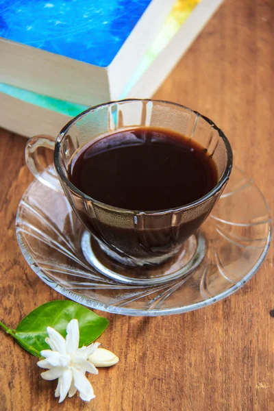 Black coffee on wooden table with old books and Jasmine flower — Stock Photo, Image