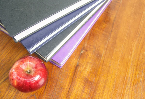 Pomme rouge et vieux livres sur table en bois — Photo