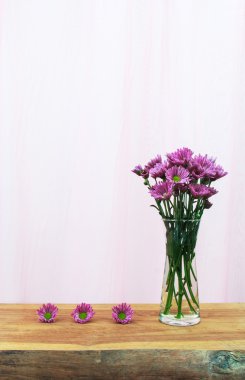 romantik ahşap masa ve beyaz bez arka cam sürahi papatya mor bir buket