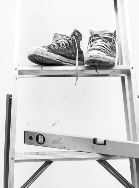 Water level  and Blue sneakers on Aluminium ladder with wall dir — Stock Photo, Image