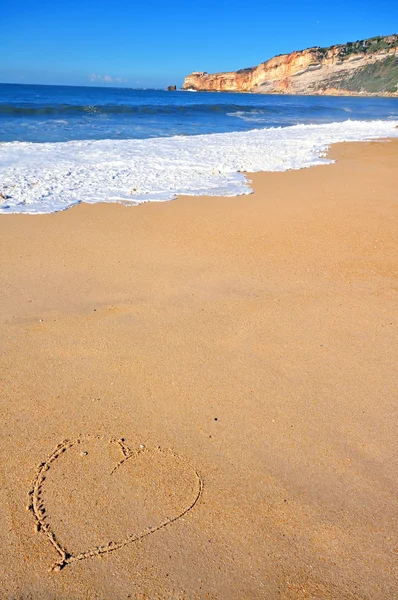 Het hart op het gouden strand zand — Stockfoto