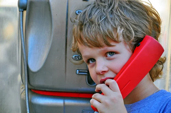 Small child talking by public phone — Stock Photo, Image