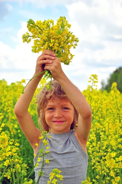 Smiling boy with yellow flowers — Stock Photo, Image