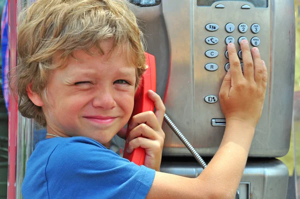 Litet barn prata genom offentlig telefon — Stockfoto