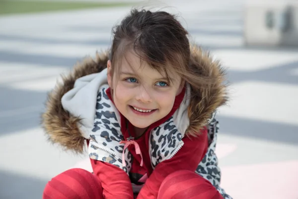 Smiling girl sitting on the road — Stock Photo, Image