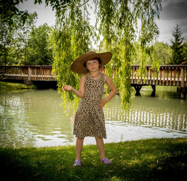 Little girl on the pond's bank — Stock Photo, Image