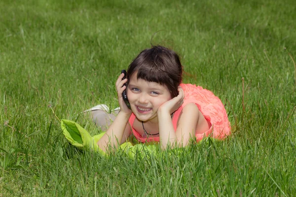 Pequena menina sorridente feliz falando no celular — Fotografia de Stock